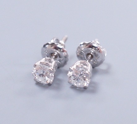 A pair of 18k white metal and solitaire diamond set ear studs, gross weight 0.9 grams